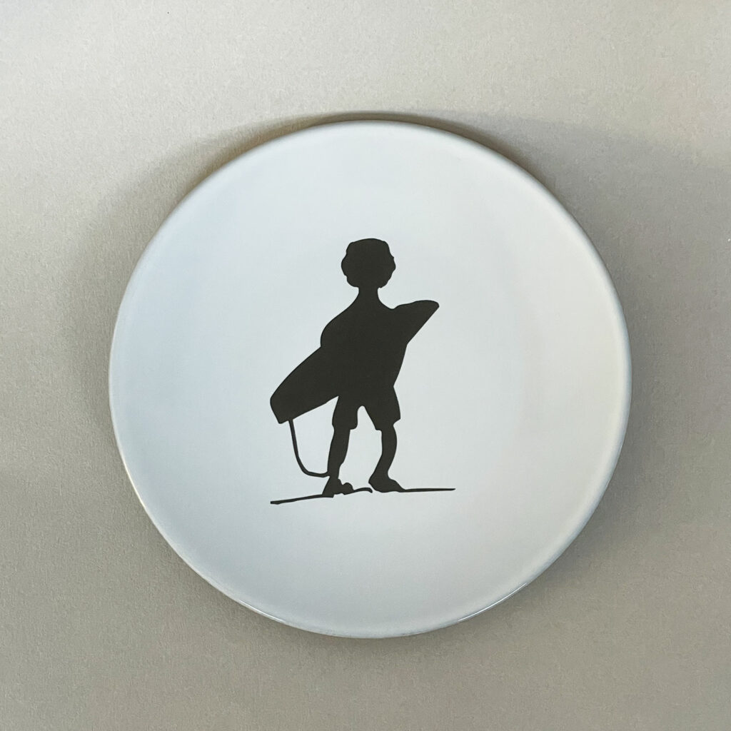 une assiette en porcelaine noire avec un emaillage blanc et le surfeur d'assiettes et compagnie, porcelaine française revol