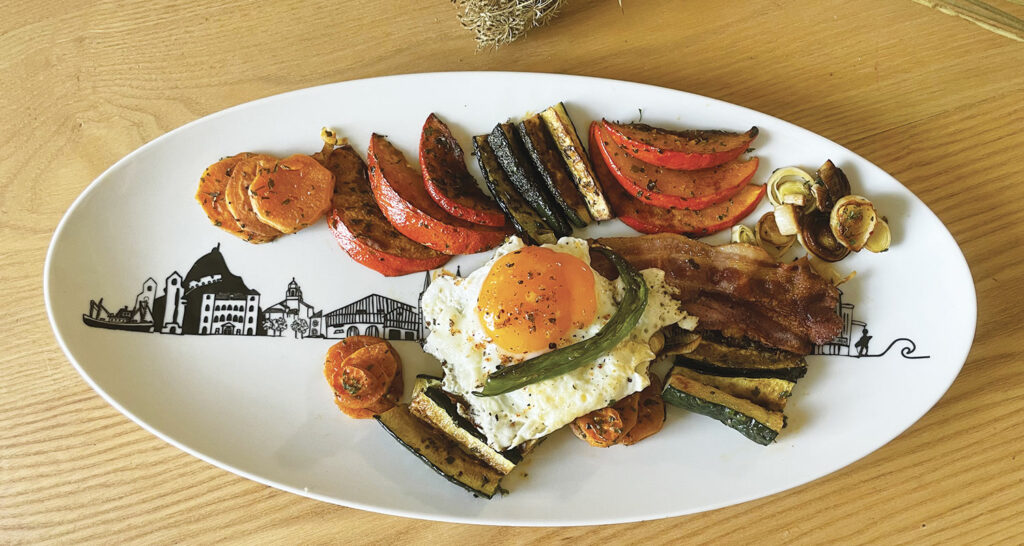 une assiette de légumes d'automne qui apporte du réconfort avec son oeuf et sa ventreche basque, une recette idéale pour les premiers jours d'automne où l'on profite des derniers piments doux et courgettes du jardin et en même temps des premiers légumes d"hiver.... présentation sur le grand plat ovale basque d'assiettes et compagnie